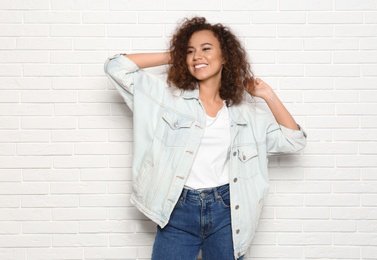 Young African-American woman with beautiful face near white brick wall