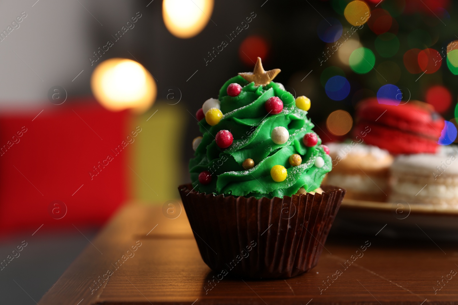 Photo of Christmas tree shaped cupcake on wooden table indoors