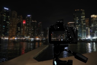 Image of DUBAI, UNITED ARAB EMIRATES - NOVEMBER 03, 2018: Night cityscape of marina district. Taking photo with camera mounted on tripod