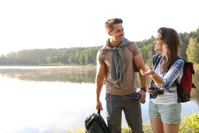 Young couple on shore of beautiful lake. Camping season