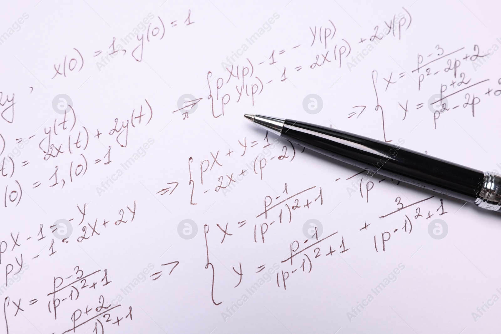 Photo of Sheet of paper with mathematical formulas and pen, closeup