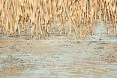 Photo of Heap of dried hay on light wooden background, flat lay. Space for text