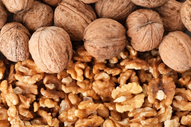 Photo of Many tasty walnuts as background, top view