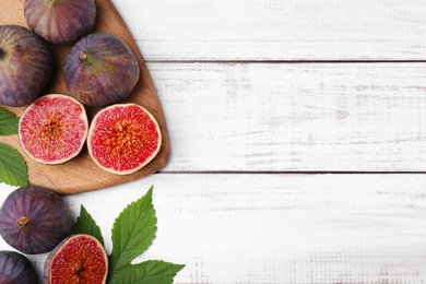 Photo of Fresh ripe purple figs on white wooden table, flat lay. Space for text