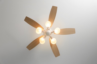 Modern ceiling fan with lamps indoors, bottom view