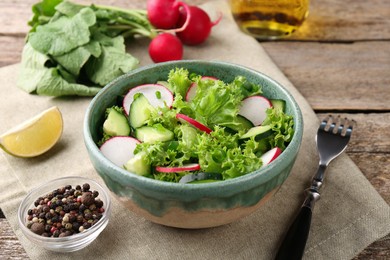 Delicious salad with radish in bowl served on table