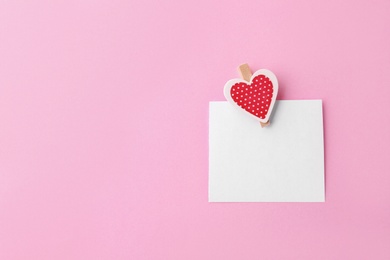 Blank paper with small heart on pink background, top view. Space for text