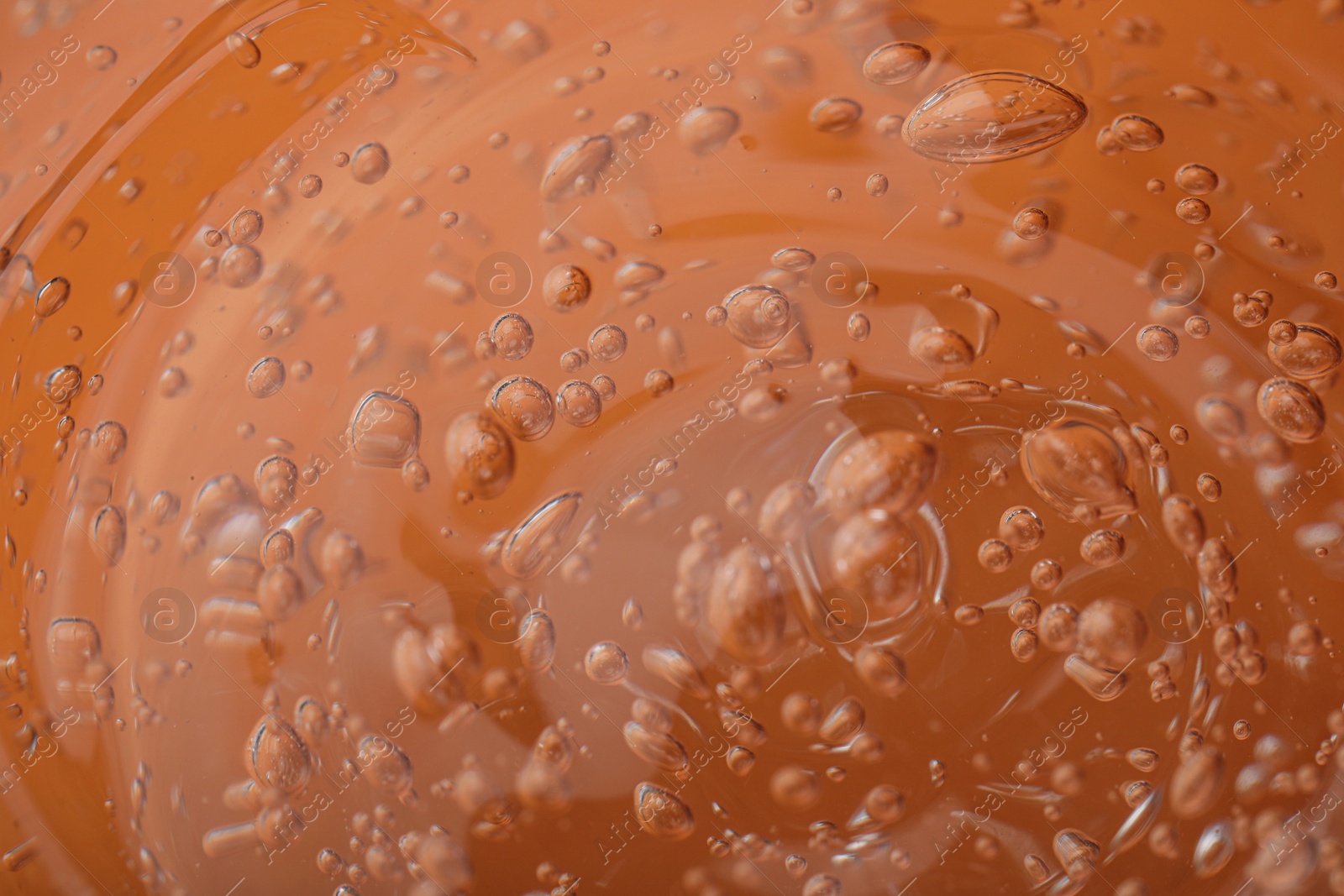 Photo of Pure transparent cosmetic gel on orange background, closeup