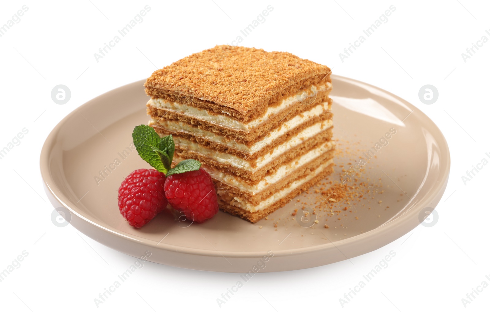 Photo of Slice of delicious layered honey cake with mint and raspberries on white background