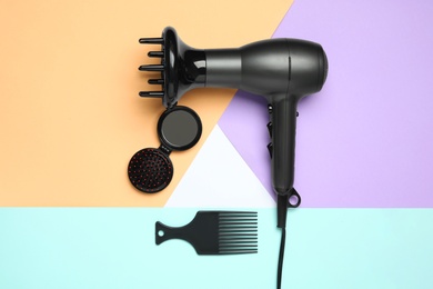 Photo of Hair dryer and different brushes on color background, flat lay. Professional hairdresser tool