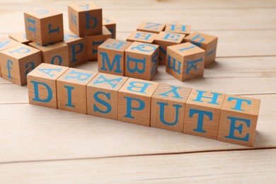 Cubes with word Dispute on light wooden table