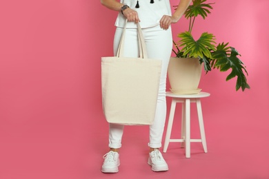 Photo of Woman with eco bag near green plant on color background. Mock up for design