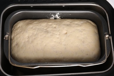 Modern bread maker with raw dough, above view