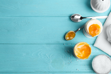 Photo of Soft boiled chicken eggs served on light blue wooden table, flat lay. Space for text