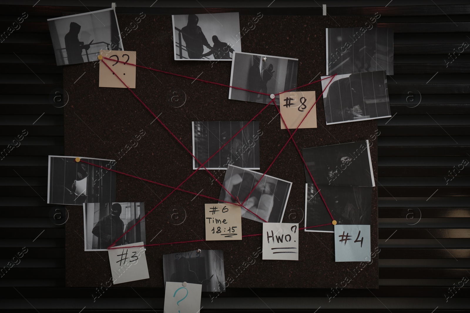 Photo of Detective board with crime scene photos, stickers, clues and red thread on wall