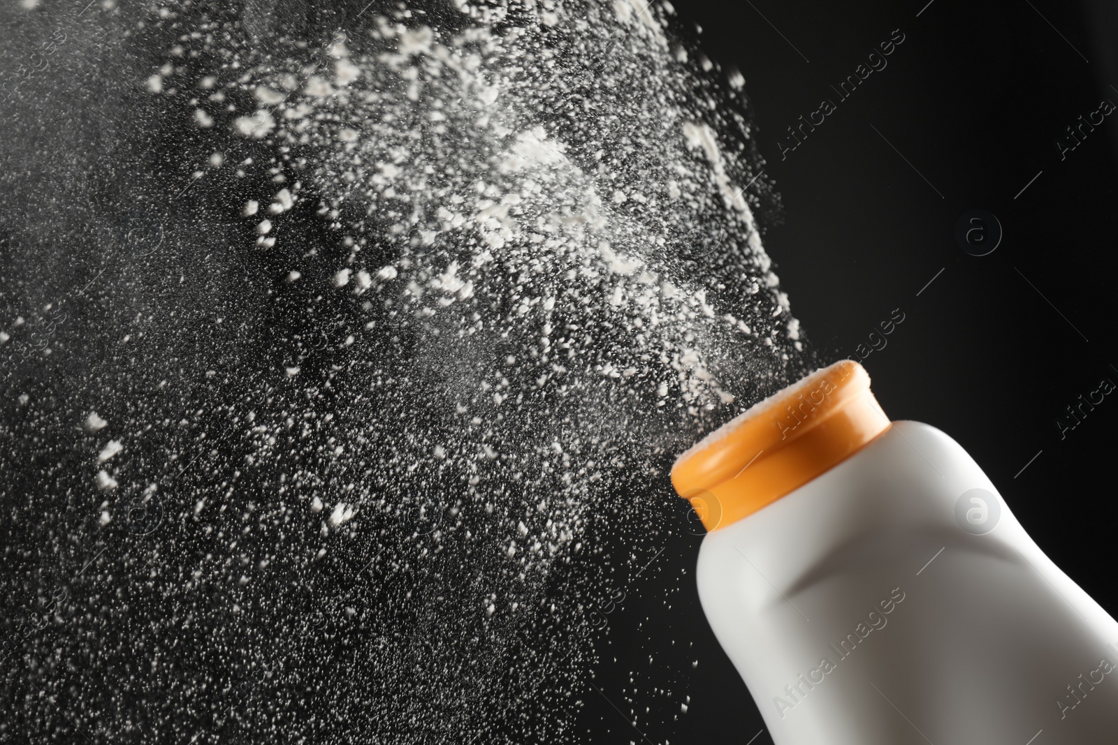 Photo of Scattering of dusting powder on black background