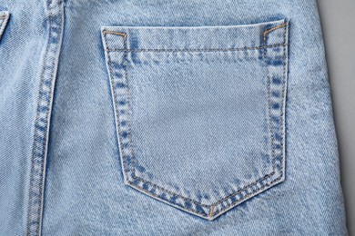 Photo of Jeans with pocket on grey background, top view