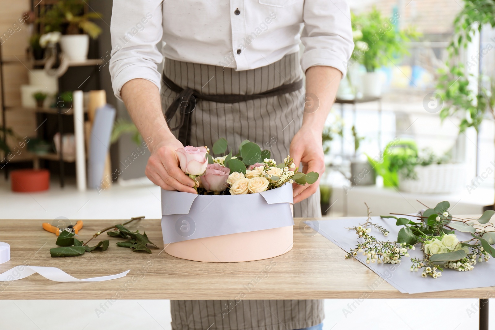 Photo of Male florist creating floral composition at workplace