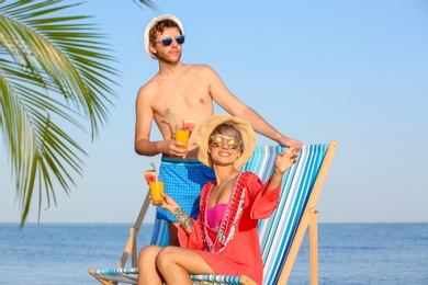 Photo of Young couple with exotic cocktails on beach