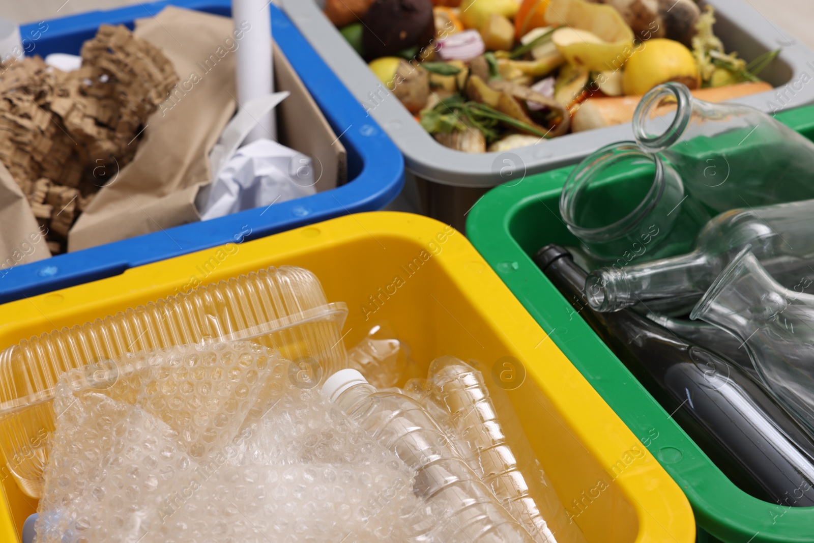 Photo of Garbage sorting. Full trash bins for separate waste collection indoors, closeup