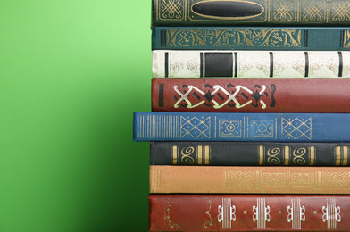 Photo of Stack of different hardcover books on green background