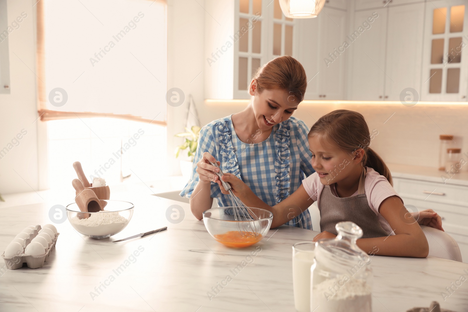 Photo of Mother and daughter making dough together in kitchen