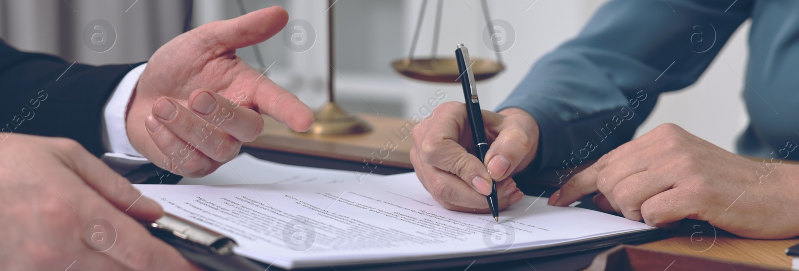 Image of Lawyer pointing at document and client putting signature at table in office, closeup. Banner design