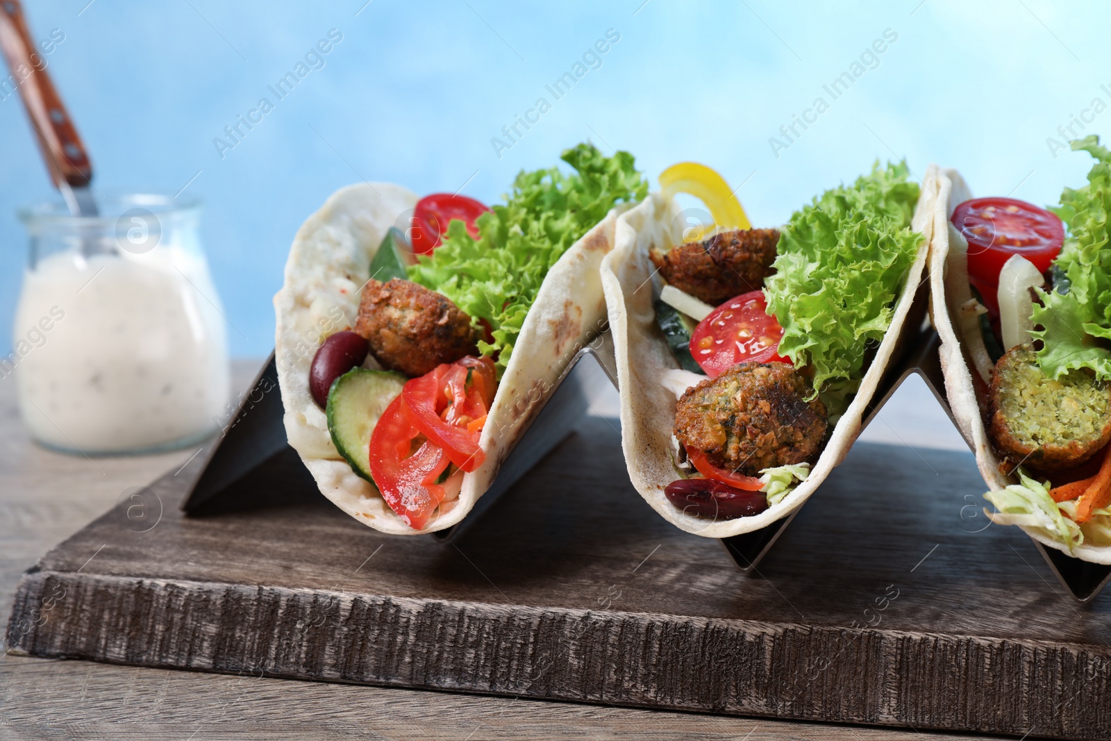 Photo of Delicious fresh vegan tacos served on wooden table