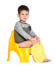 Photo of Portrait of little boy sitting on potty against white background
