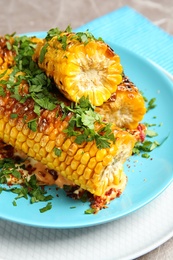 Photo of Plate with delicious grilled corn cobs and parsley on table, closeup