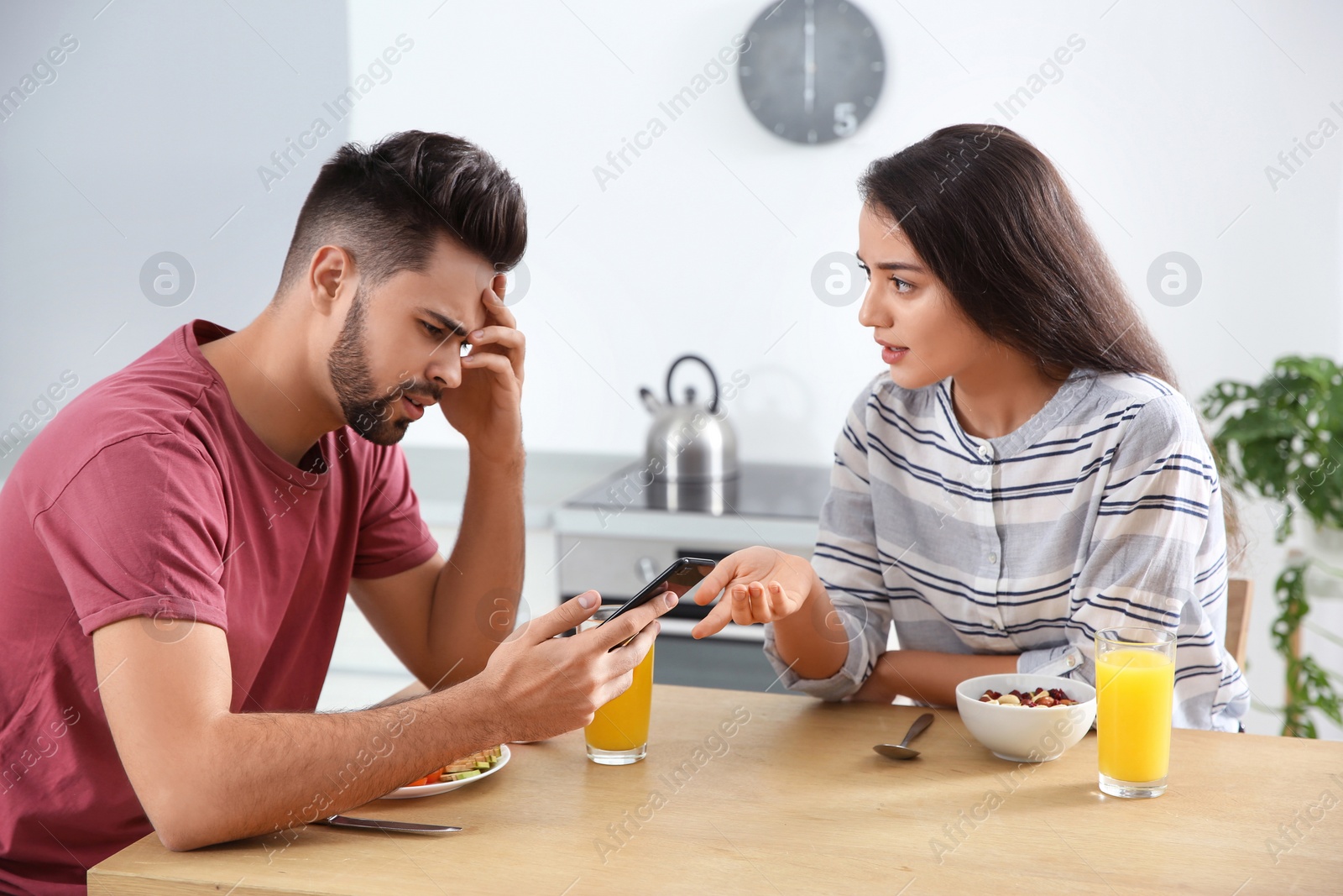 Photo of Young man with smartphone ignoring his girlfriend at home