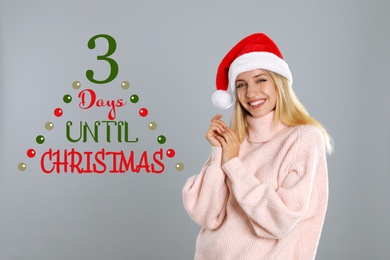 Image of Christmas countdown. Happy woman wearing Santa hat on light grey background near text