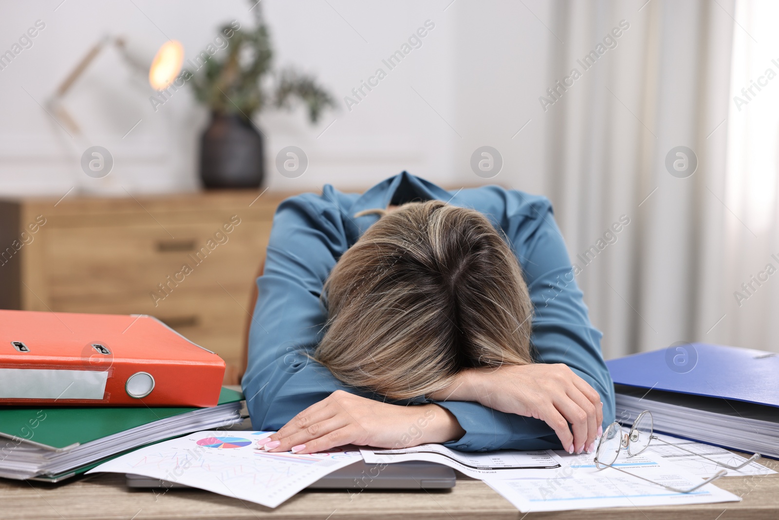 Photo of Office worker sleeping at workplace. Overwhelmed by work