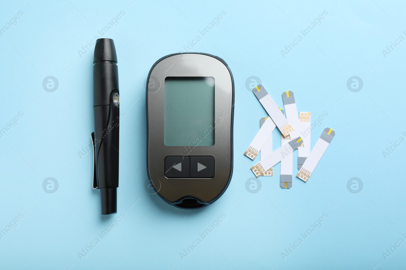 Photo of Digital glucometer, lancet pen and test strips on light blue background, flat lay. Diabetes control