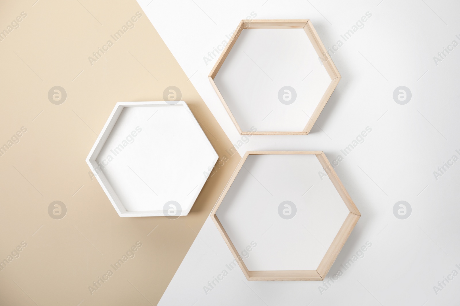 Photo of Empty honeycomb shaped shelves on color wall