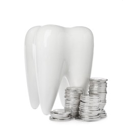 Photo of Ceramic model of tooth and coins on white background. Expensive treatment