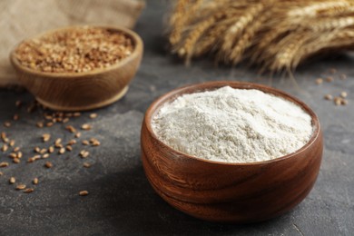 Wooden bowl of flour on grey table. Space for text