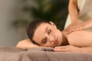 Photo of Beautiful young woman enjoying massage in spa salon