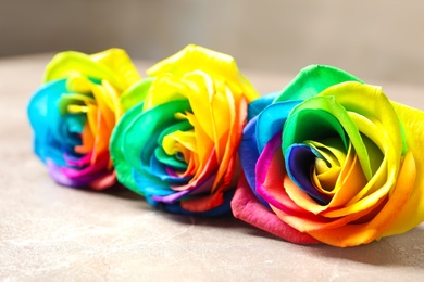 Photo of Amazing rainbow rose flowers on table