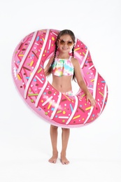 Photo of Cute little child in beachwear with bright inflatable ring on white background