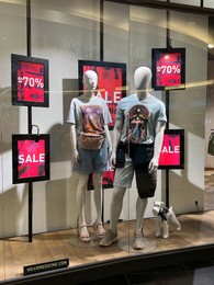Photo of WARSAW, POLAND - JULY 17, 2022: Medicine store display with clothes on mannequins in shopping mall
