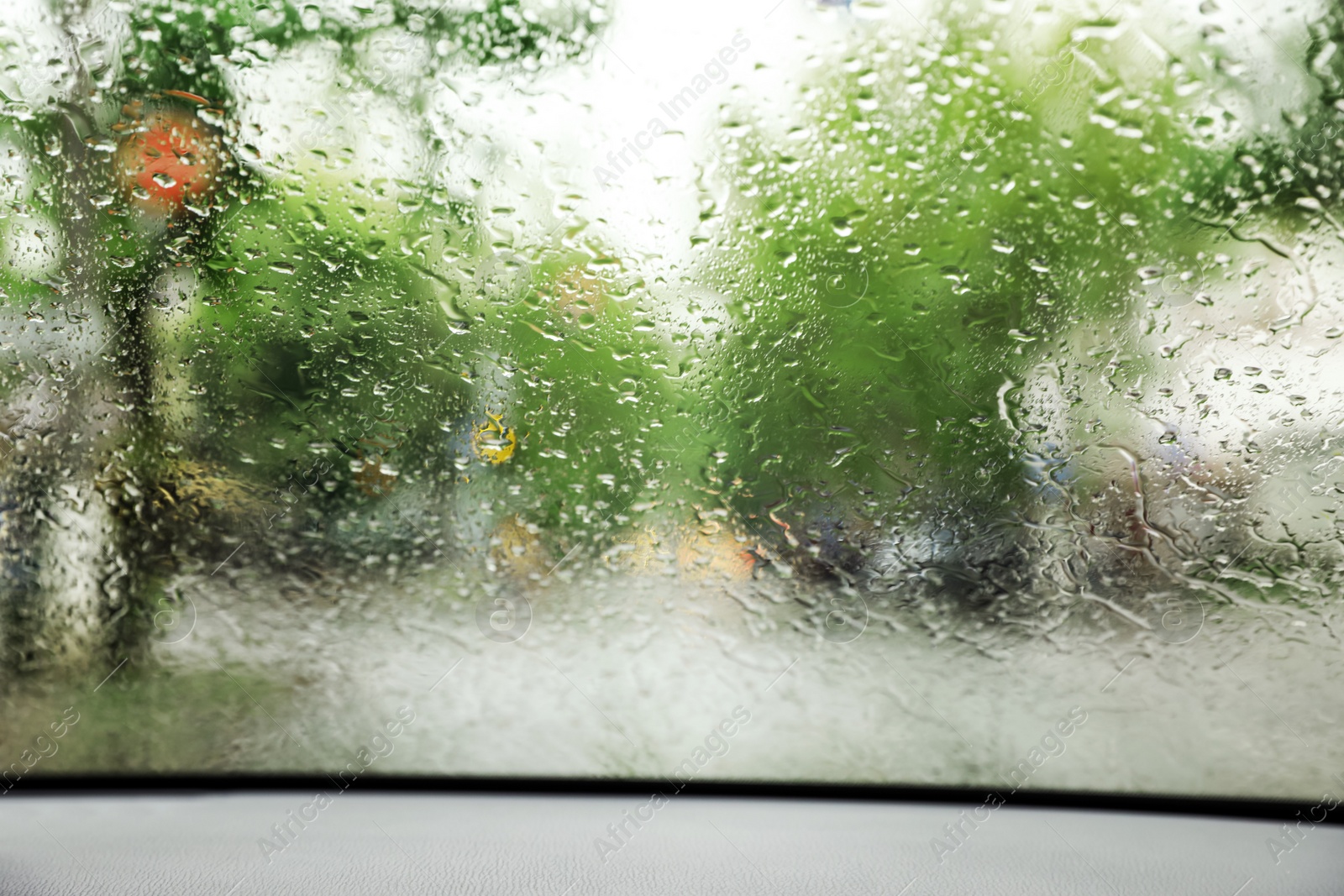 Photo of Blurred view of road through wet car window. Rainy weather