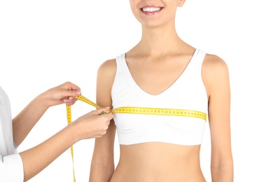 Photo of Doctor measuring size of patient's breast on white background, closeup. Cosmetic surgery