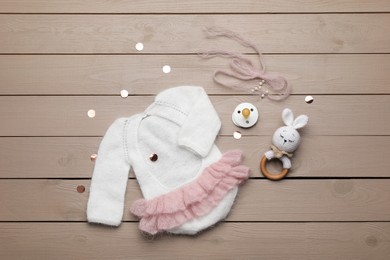 Photo of Flat lay composition with cute baby knitwear for photoshoot on wooden background