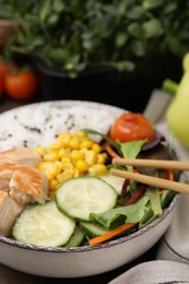 Photo of Delicious poke bowl with meat, rice, vegetables and greens on wooden table, closeup