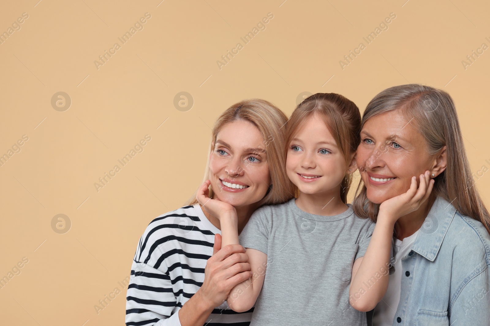 Photo of Three generations. Happy grandmother, her daughter and granddaughter on beige background, space for text