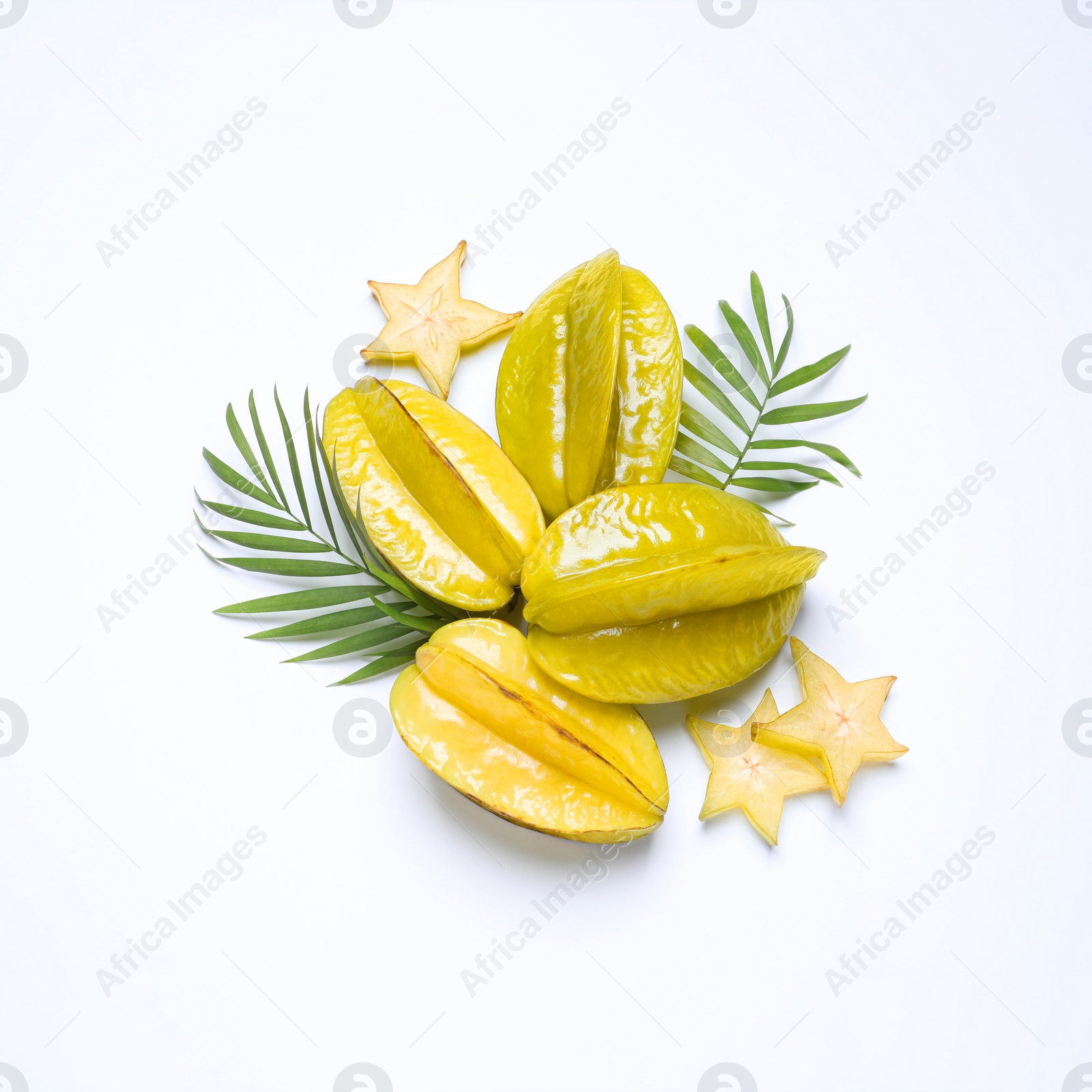 Photo of Delicious carambola fruits and leaves on white background, flat lay