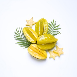 Delicious carambola fruits and leaves on white background, flat lay