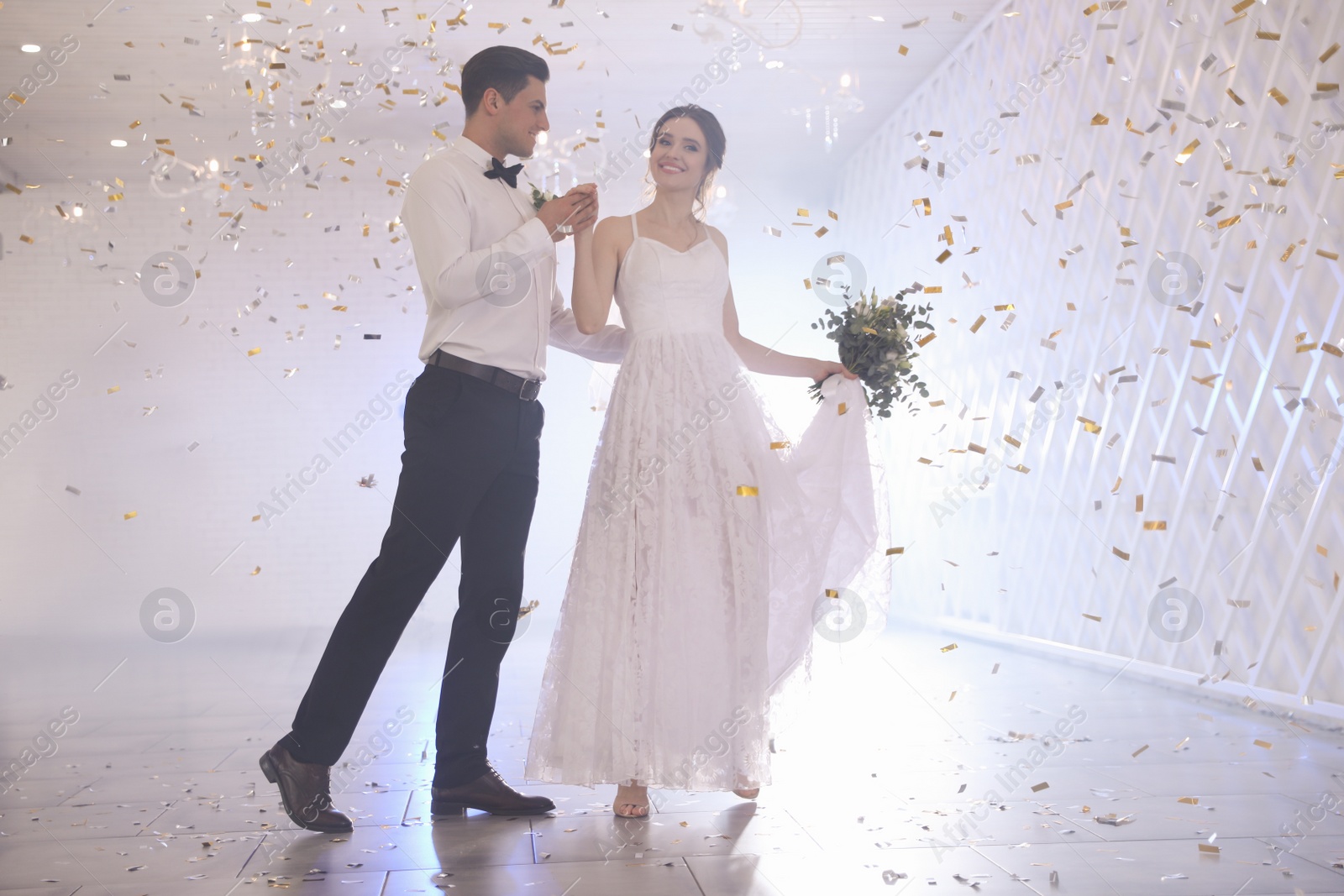 Photo of Happy newlywed couple dancing together in festive hall