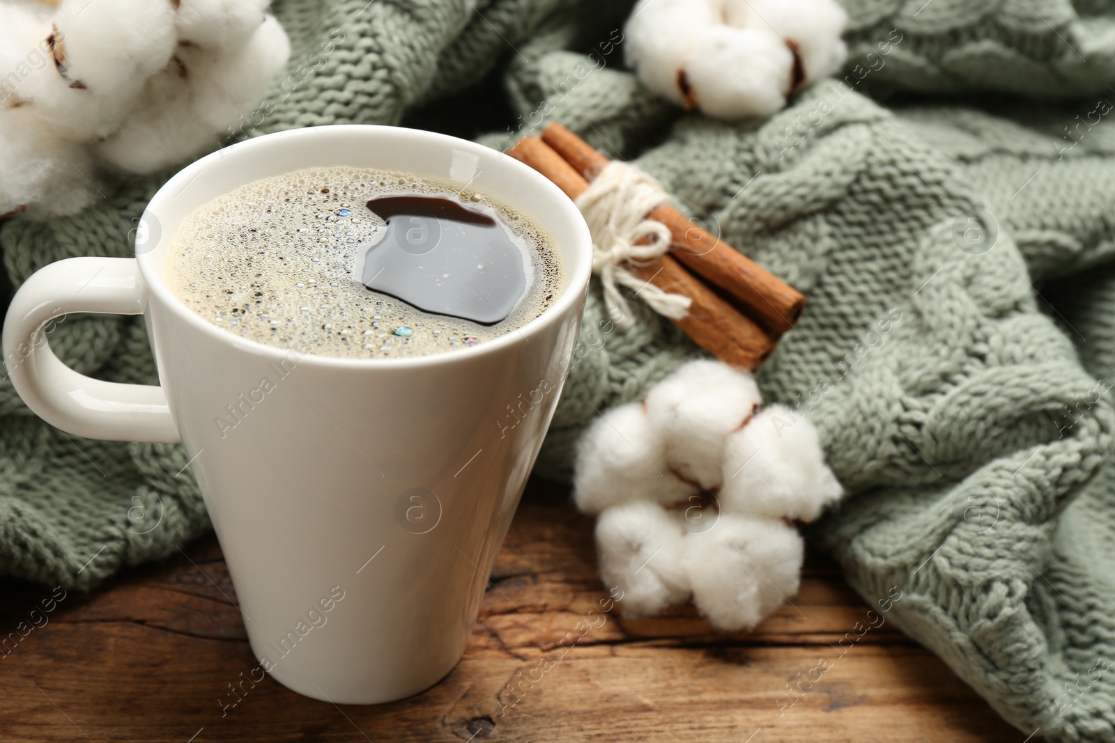 Photo of Composition with hot drink and warm plaid on wooden table, closeup